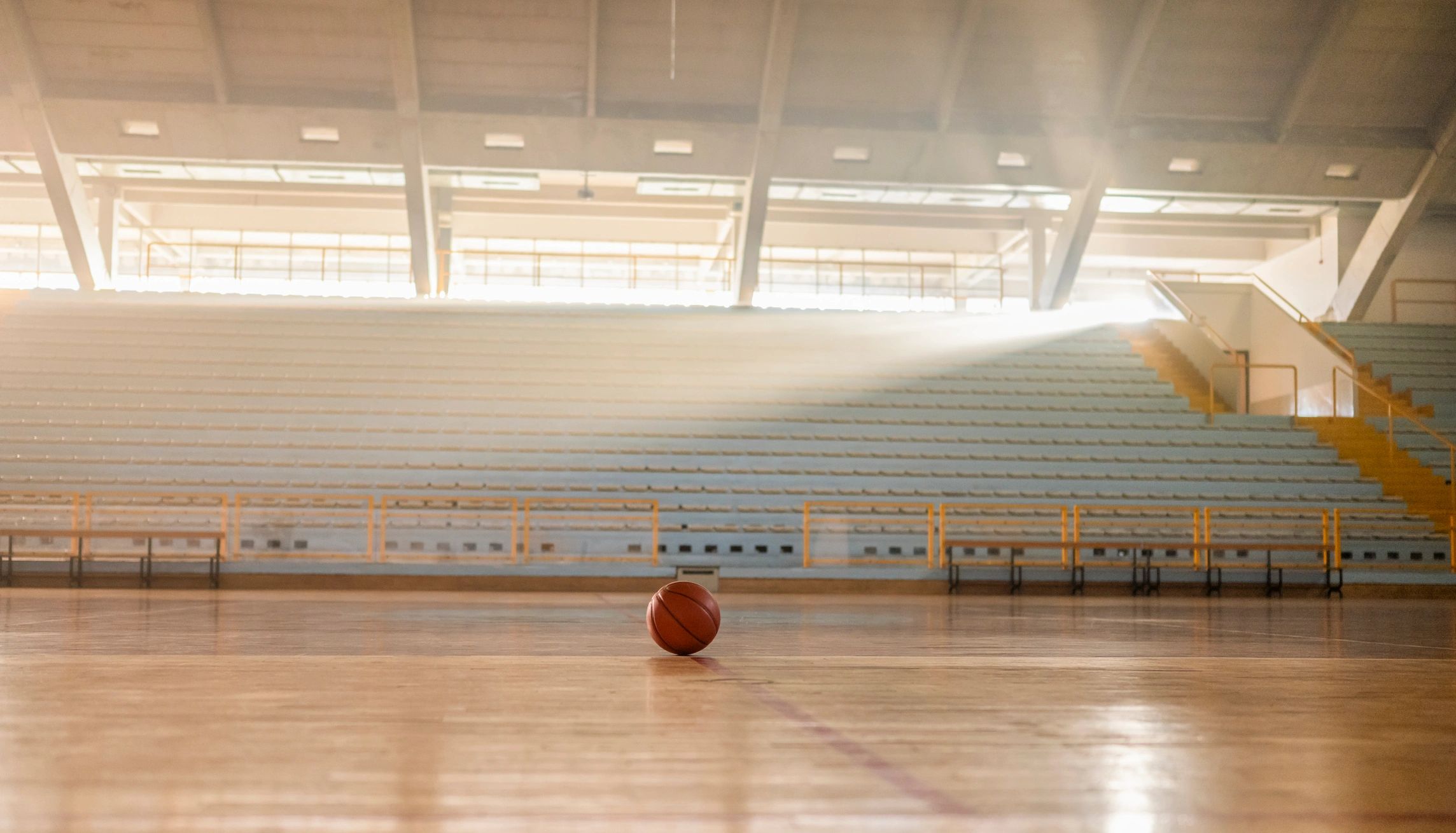 Empty indoor basketball court with a ball